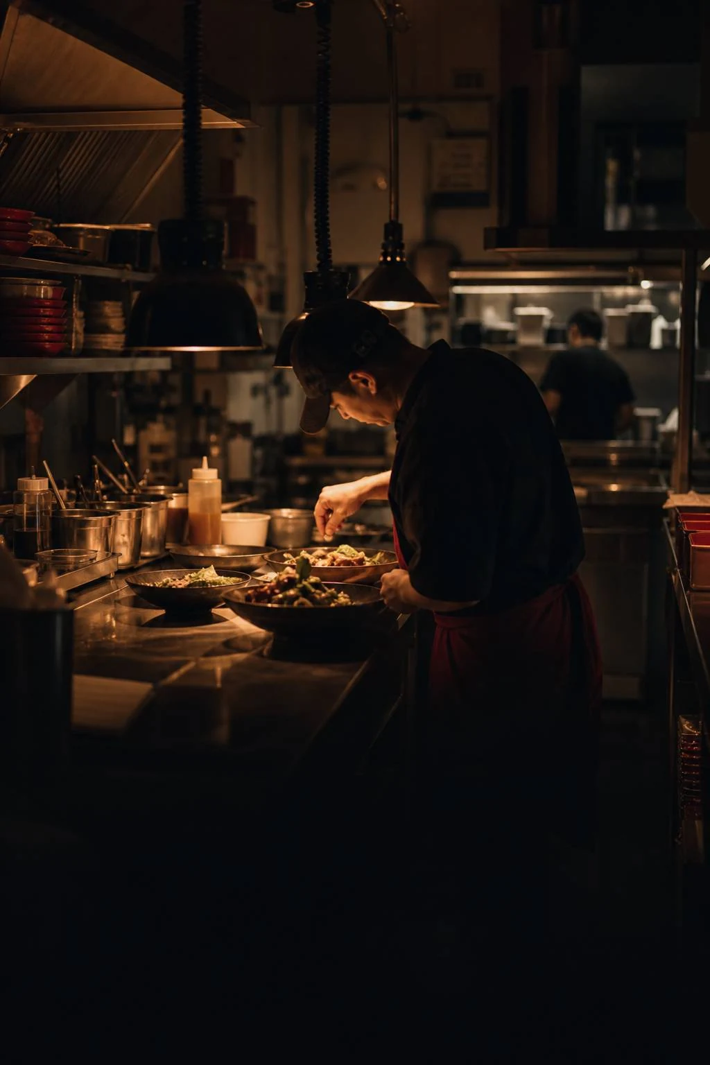 A chef plating dishes in a working restaurant kitchen, from Mamal’s website.